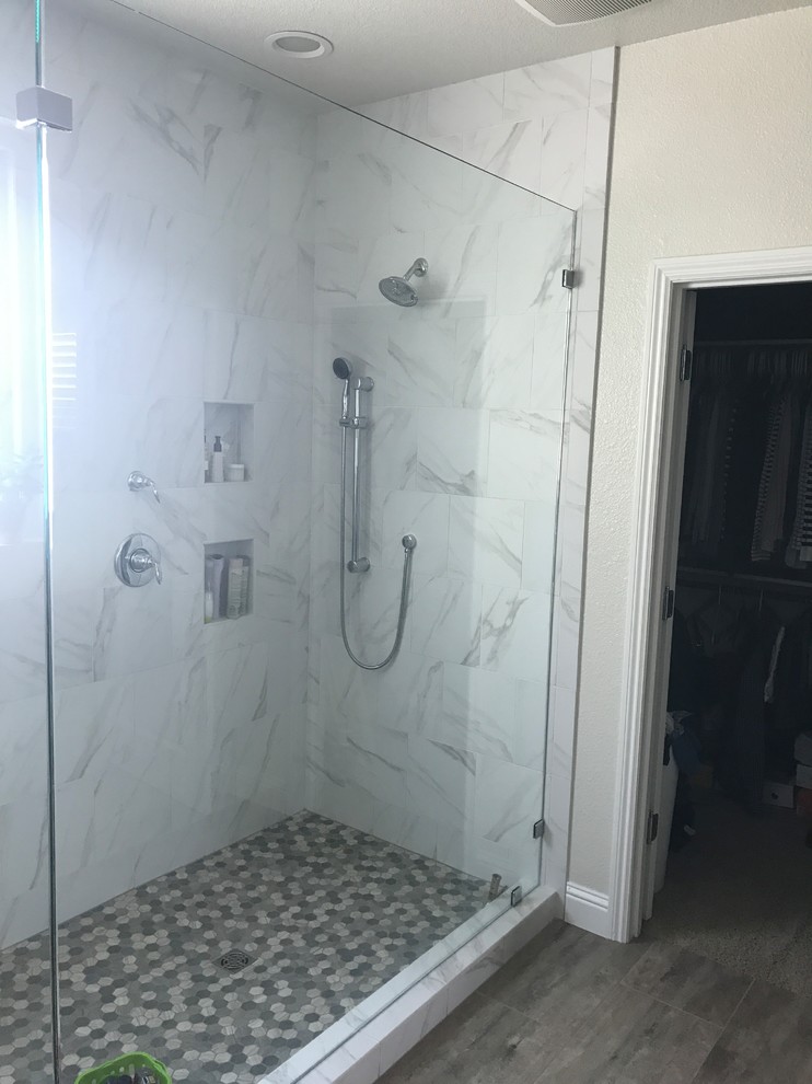 Idéer för att renovera ett stort funkis en-suite badrum, med en toalettstol med separat cisternkåpa, vit kakel, porslinskakel, vita väggar, klinkergolv i porslin, brunt golv och dusch med gångjärnsdörr