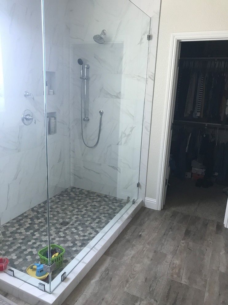 This is an example of a large contemporary ensuite bathroom in Sacramento with a two-piece toilet, white tiles, porcelain tiles, white walls, porcelain flooring, brown floors and a hinged door.