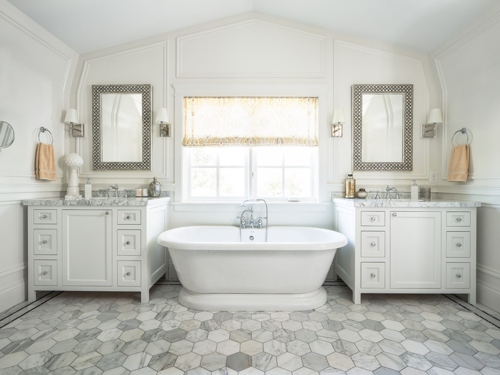 Diseño de cuarto de baño principal tradicional con armarios estilo shaker, puertas de armario blancas, bañera exenta, paredes blancas y ventanas