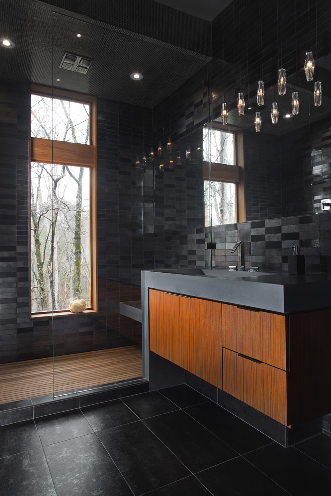 Exempel på ett mellanstort modernt badrum, med ett avlångt handfat, svart kakel, keramikplattor, svarta väggar, klinkergolv i porslin, släta luckor och svart golv