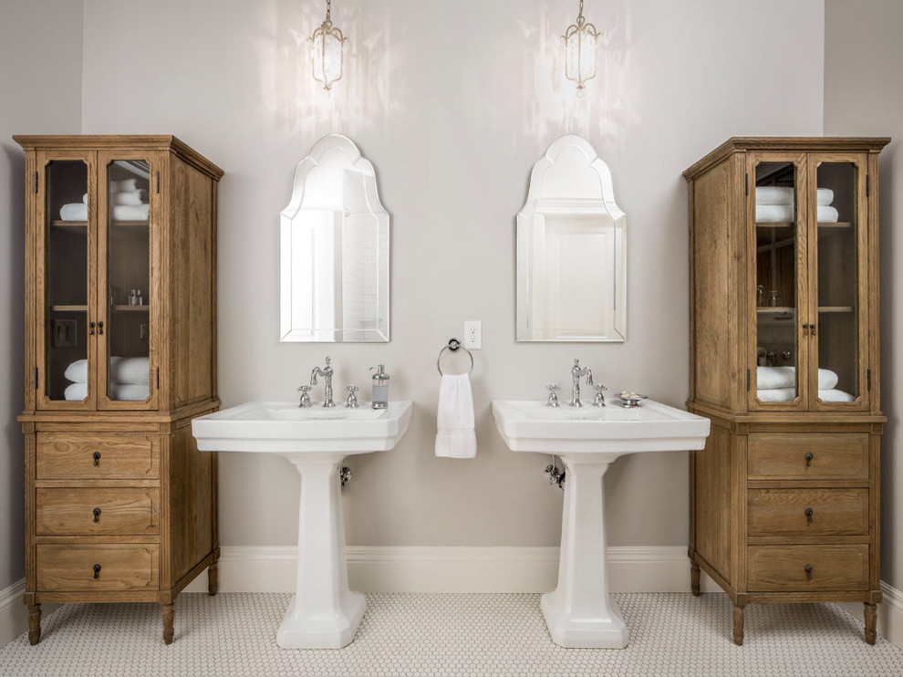Diseño de cuarto de baño tradicional con lavabo con pedestal, puertas de armario de madera oscura y baldosas y/o azulejos blancos