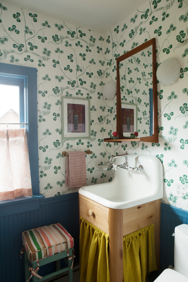 Modelo de cuarto de baño único y de pie romántico de tamaño medio con armarios con paneles lisos, puertas de armario de madera clara, paredes multicolor, aseo y ducha, lavabo integrado y papel pintado