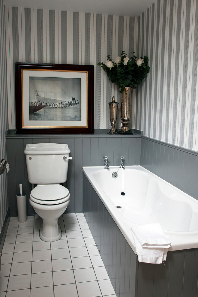 Esempio di una piccola stanza da bagno tradizionale con vasca da incasso, WC monopezzo e pavimento bianco