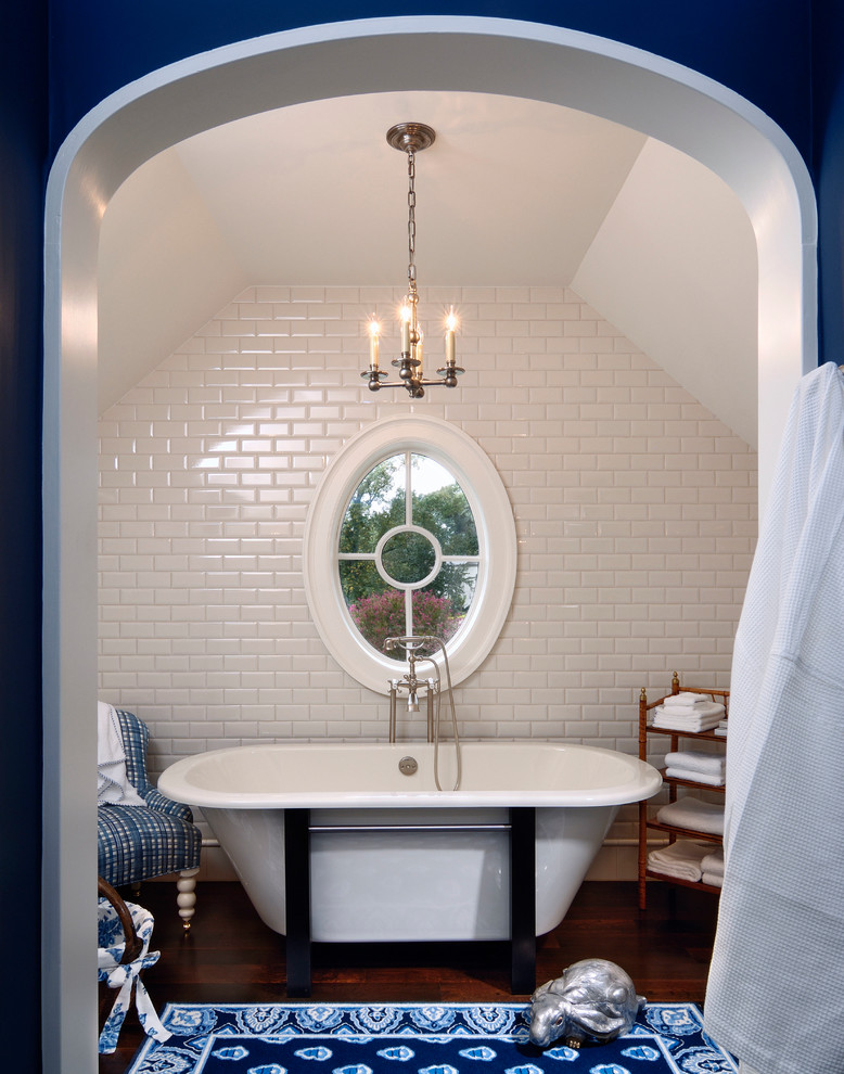На фото: ванная комната в классическом стиле с отдельно стоящей ванной, белой плиткой, плиткой кабанчик, белыми стенами и темным паркетным полом