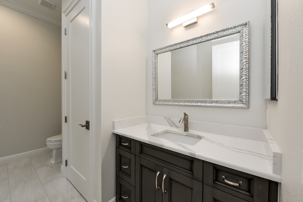 Doorless shower - large transitional kids' multicolored tile and porcelain tile porcelain tile doorless shower idea in Tampa with recessed-panel cabinets, gray cabinets, a two-piece toilet, white walls, an undermount sink and quartz countertops