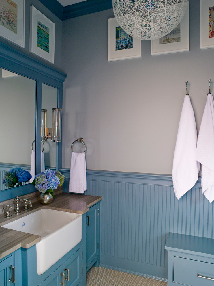 Immagine di una stanza da bagno classica con lavabo sottopiano, ante blu, pareti blu, top marrone, pavimento con piastrelle in ceramica, top in marmo, pavimento beige e ante a filo