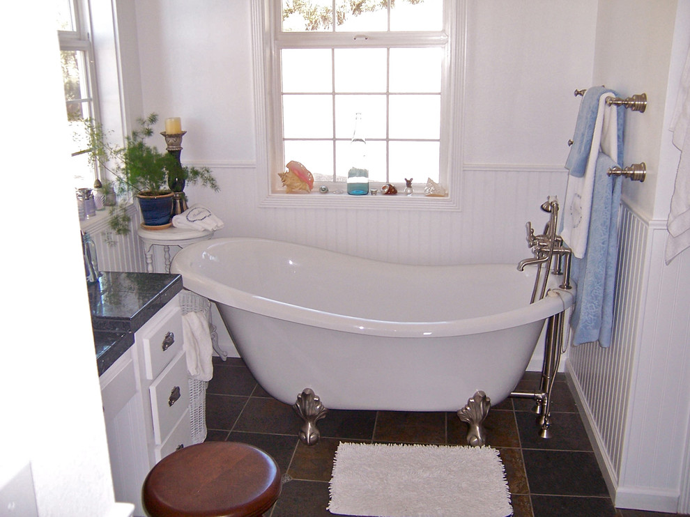 Réalisation d'une petite salle de bain champêtre avec des portes de placard blanches, un plan de toilette en granite, une baignoire sur pieds, un carrelage marron, un mur blanc et un sol en carrelage de céramique.