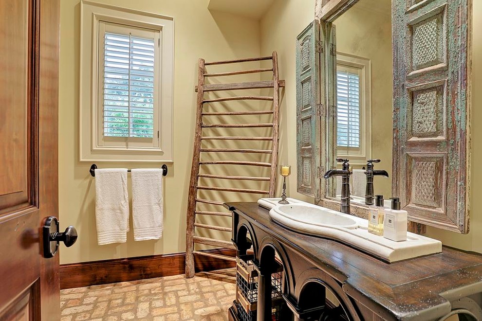 Immagine di una stanza da bagno con doccia tradizionale di medie dimensioni con consolle stile comò, ante in legno bruno, piastrelle beige, pareti beige, pavimento in mattoni, lavabo da incasso e top in legno