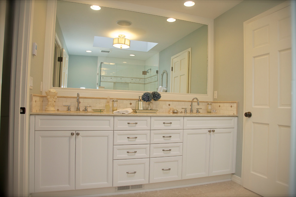 Example of a mid-sized classic white tile marble floor walk-in shower design in Seattle with an undermount sink, a two-piece toilet, recessed-panel cabinets, white cabinets, marble countertops and blue walls