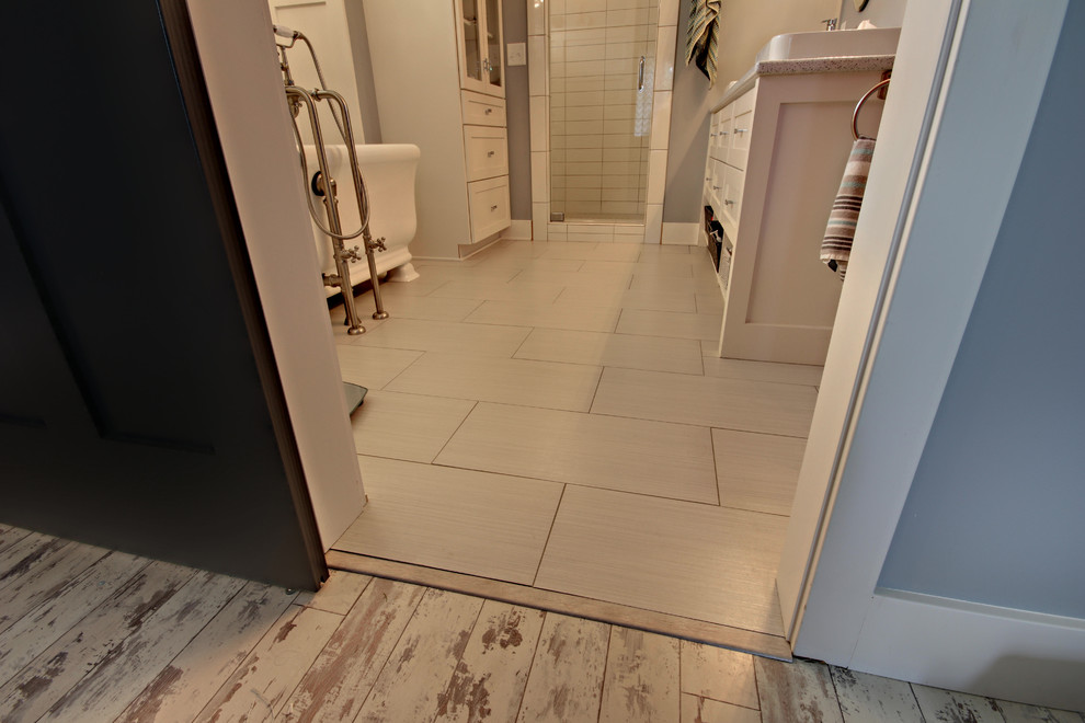 Example of a mid-sized trendy master porcelain tile and white floor bathroom design in Grand Rapids with recessed-panel cabinets, white cabinets, white walls, a vessel sink, quartz countertops and a hinged shower door