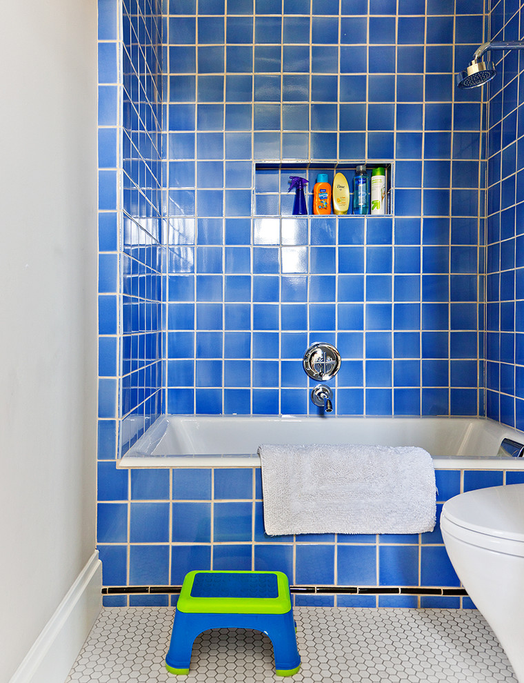 Modelo de cuarto de baño infantil clásico con combinación de ducha y bañera, baldosas y/o azulejos azules y suelo con mosaicos de baldosas