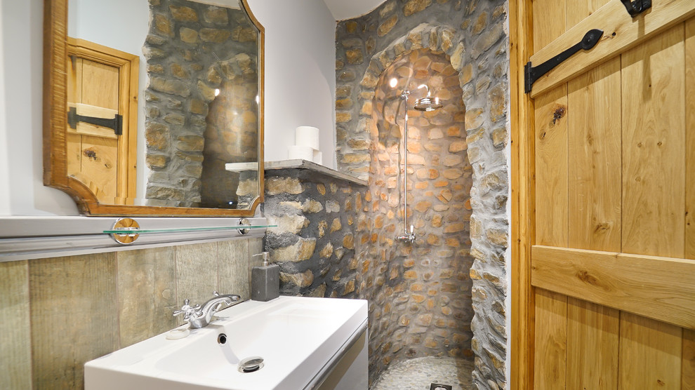 Cette photo montre une douche en alcôve nature avec un carrelage beige, un carrelage de pierre, un mur blanc, un lavabo intégré, un plan de toilette blanc et un mur en pierre.