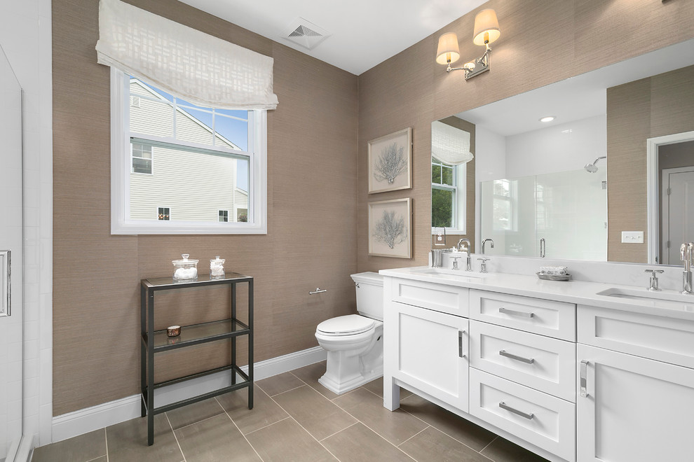 Inspiration for a mid-sized contemporary master porcelain tile and brown floor alcove shower remodel in New York with shaker cabinets, white cabinets, a two-piece toilet, brown walls, an undermount sink, a hinged shower door and white countertops