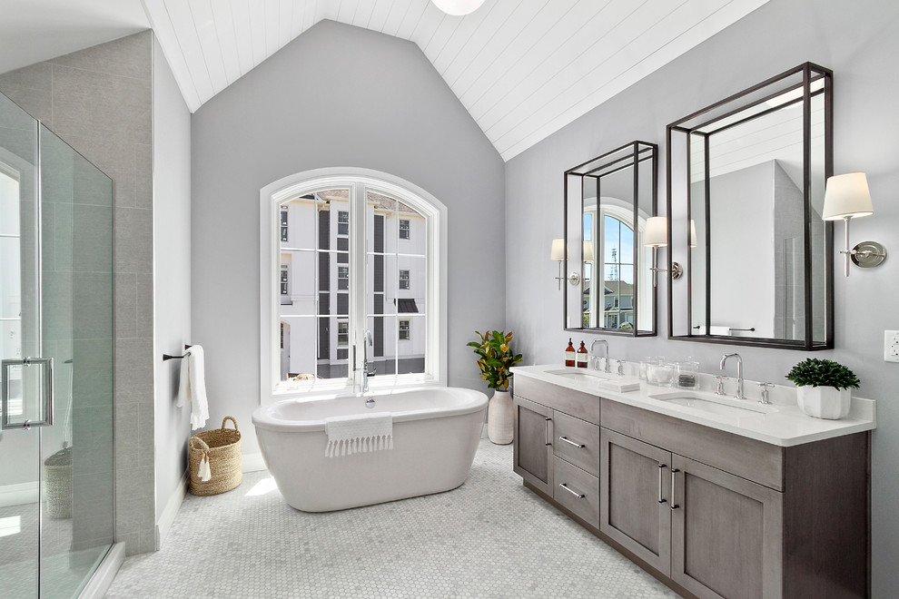 Cette photo montre une douche en alcôve chic avec un placard à porte shaker, des portes de placard grises, une baignoire indépendante, un mur gris, un lavabo encastré, un sol gris, une cabine de douche à porte battante, un plan de toilette blanc et un sol en marbre.