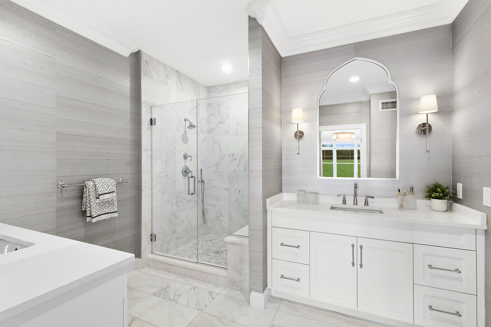 Corner shower - transitional master marble tile marble floor and white floor corner shower idea in New York with white cabinets, gray walls, an undermount sink, quartzite countertops, white countertops, shaker cabinets and a hinged shower door