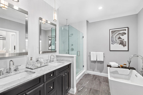 Modern bathroom with Black Bathroom Cabinets, marble countertop, glass shower, and freestanding tub in Mississauga home