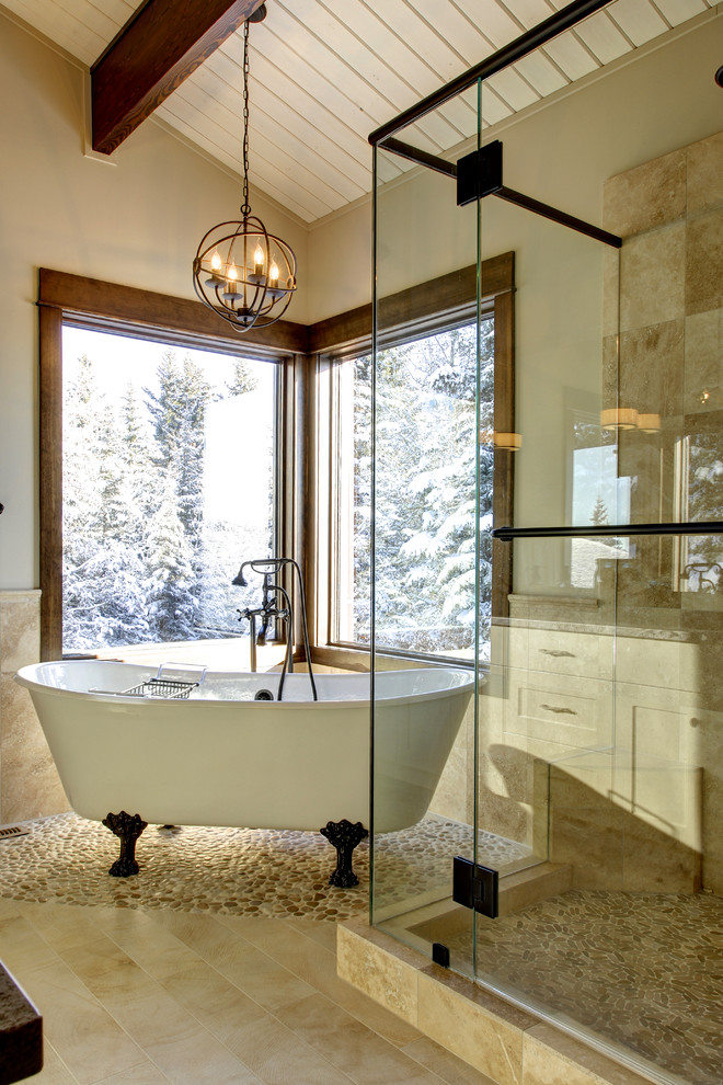 Idée de décoration pour une douche en alcôve tradition avec une baignoire sur pieds, un carrelage beige, un plan de toilette en granite, une plaque de galets, un sol en galet et un sol beige.