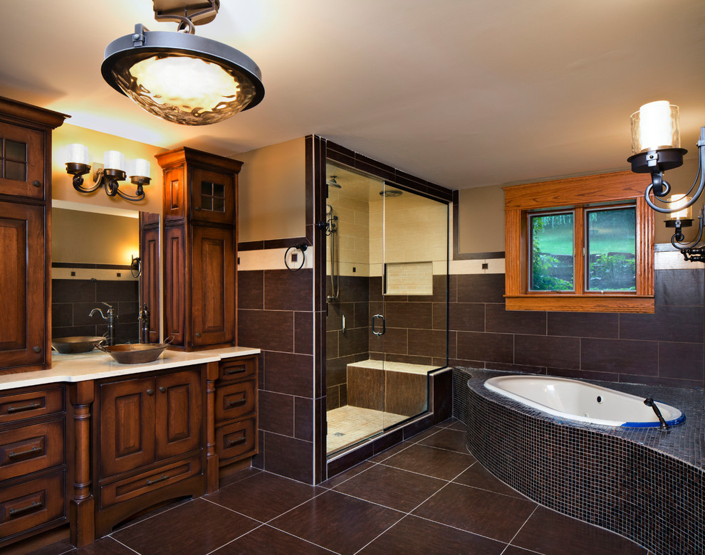 Photo of a classic bathroom in Other with raised-panel cabinets, brown cabinets, a built-in bath, an alcove shower, a one-piece toilet, multi-coloured tiles, porcelain tiles, porcelain flooring, a vessel sink, engineered stone worktops, multi-coloured floors, a hinged door, white worktops and beige walls.
