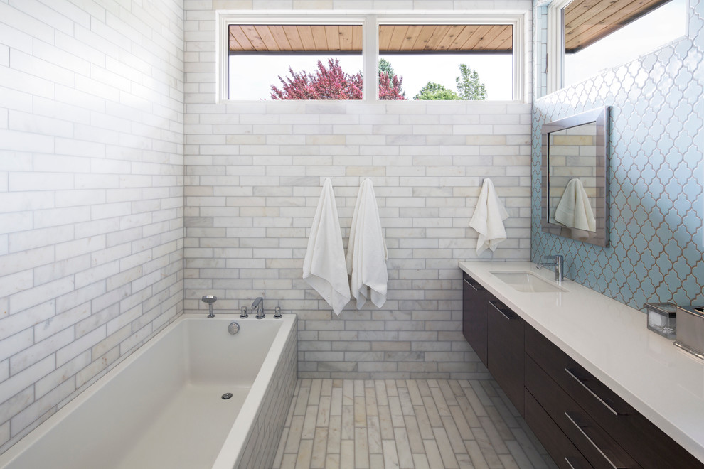 На фото: главная ванная комната среднего размера в современном стиле с врезной раковиной, плоскими фасадами, накладной ванной, синей плиткой, темными деревянными фасадами, мраморным полом и серыми стенами с