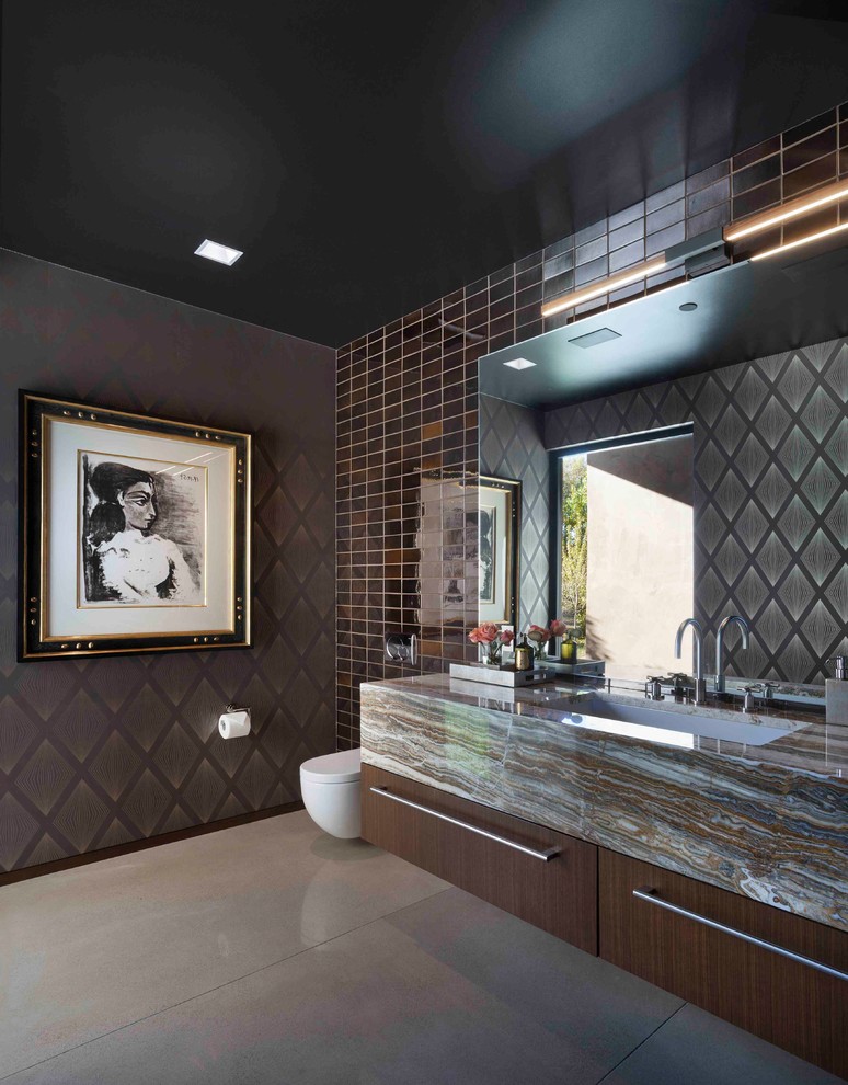 На фото: ванная комната в современном стиле с плоскими фасадами, темными деревянными фасадами, коричневой плиткой, плиткой кабанчик, коричневыми стенами, бетонным полом, врезной раковиной и серым полом