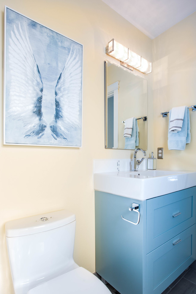 Foto på ett litet funkis en-suite badrum, med skåp i shakerstil, turkosa skåp, en dusch i en alkov, en toalettstol med hel cisternkåpa, grå kakel, glaskakel, gula väggar, klinkergolv i porslin och ett avlångt handfat