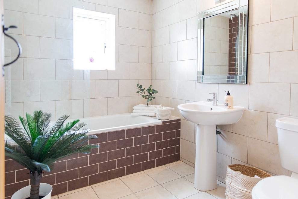 Imagen de cuarto de baño contemporáneo con bañera empotrada, combinación de ducha y bañera, baldosas y/o azulejos beige, lavabo con pedestal, suelo beige y ducha abierta