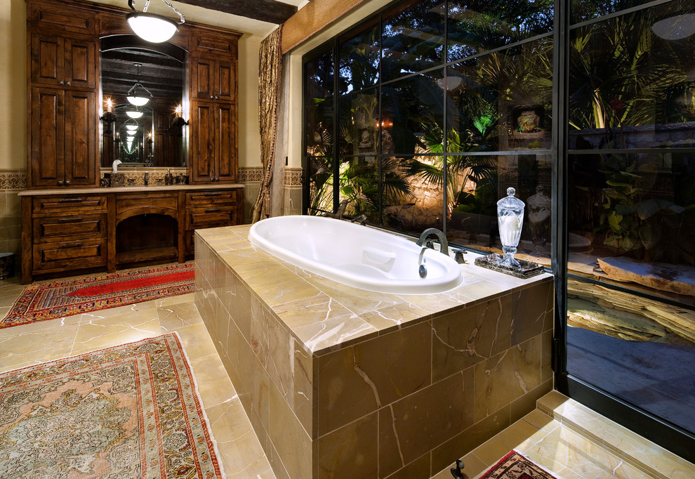 Example of a large tuscan master drop-in bathtub design in Austin with dark wood cabinets, beige walls and raised-panel cabinets