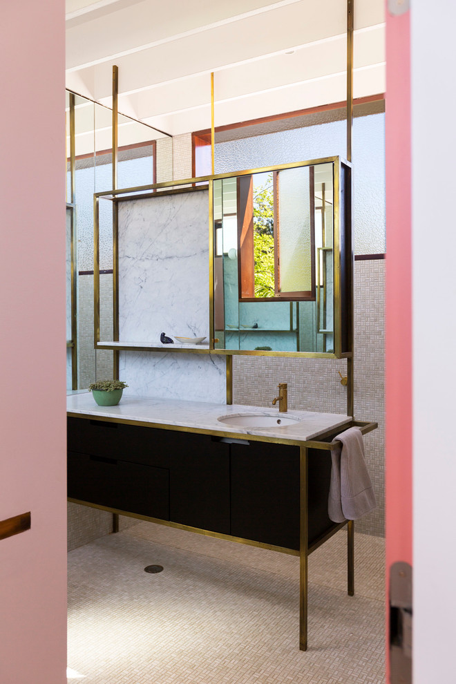 Inredning av ett mellanstort badrum, med ett undermonterad handfat, öppna hyllor, svarta skåp, marmorbänkskiva, beige kakel, mosaik, beige väggar och mosaikgolv