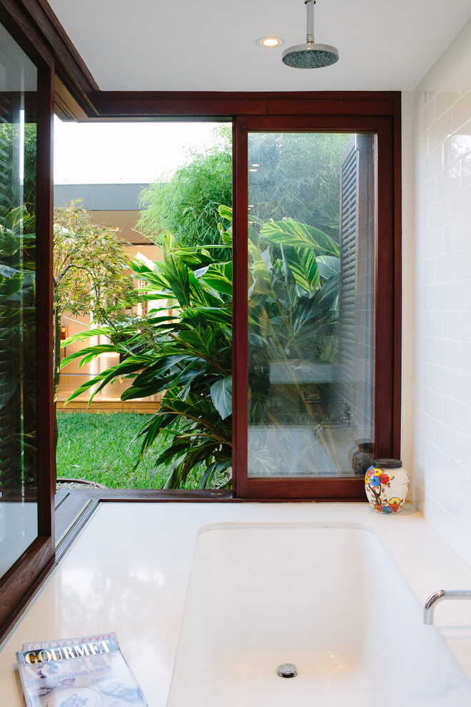 Foto de cuarto de baño contemporáneo con bañera japonesa, combinación de ducha y bañera, baldosas y/o azulejos blancos, paredes blancas y lavabo suspendido