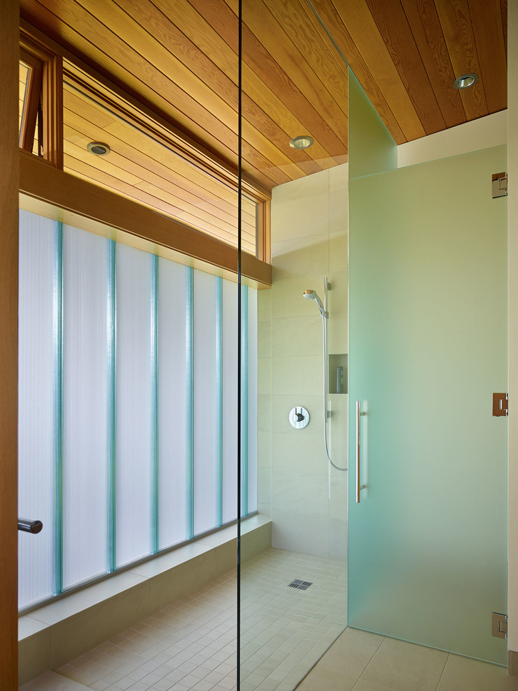 Immagine di una stanza da bagno design con doccia aperta, piastrelle beige e doccia aperta