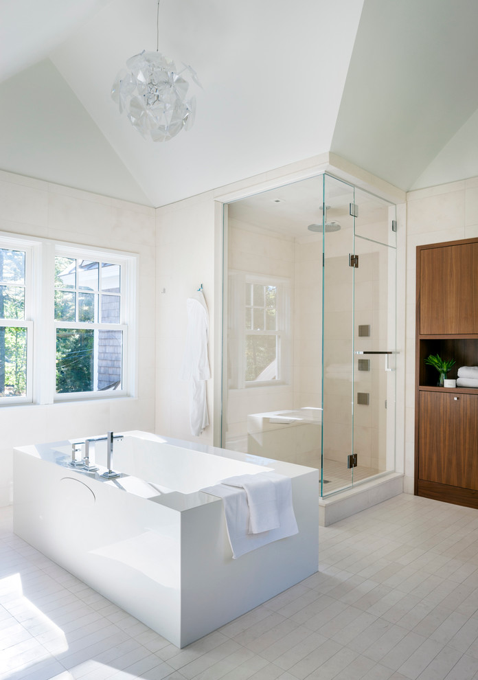 Réalisation d'une salle de bain design avec une baignoire indépendante, une douche d'angle et un carrelage beige.