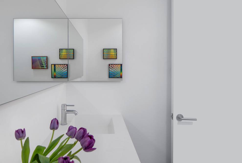 Свежая идея для дизайна: ванная комната среднего размера в стиле модернизм с плоскими фасадами, светлыми деревянными фасадами, раздельным унитазом, серой плиткой, керамогранитной плиткой, белыми стенами, полом из керамогранита, душевой кабиной, монолитной раковиной и столешницей из искусственного камня - отличное фото интерьера