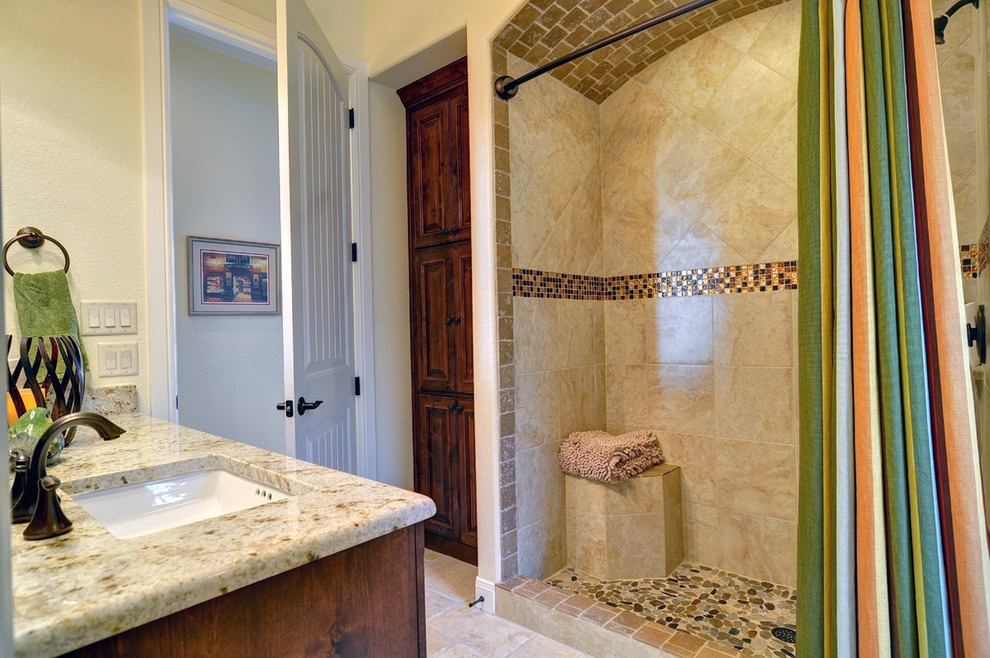 Esempio di una stanza da bagno con doccia classica di medie dimensioni con lavabo sottopiano, ante con bugna sagomata, ante in legno scuro, top in granito, doccia aperta, WC a due pezzi, piastrelle beige, piastrelle in ceramica e pareti beige