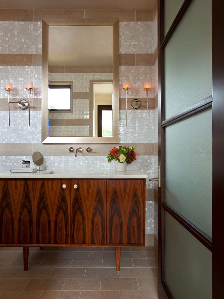 Ejemplo de cuarto de baño actual con lavabo bajoencimera, puertas de armario de madera en tonos medios, baldosas y/o azulejos blancos, baldosas y/o azulejos en mosaico y armarios con paneles lisos