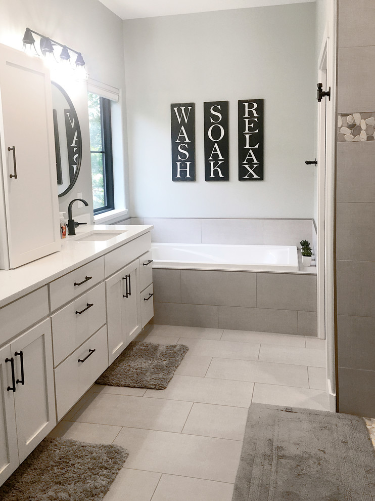 Klassisk inredning av ett stort vit vitt en-suite badrum, med skåp i shakerstil, vita skåp, ett platsbyggt badkar, en dusch i en alkov, grå kakel, porslinskakel, grå väggar, klinkergolv i porslin, ett undermonterad handfat, bänkskiva i kvarts, grått golv och med dusch som är öppen