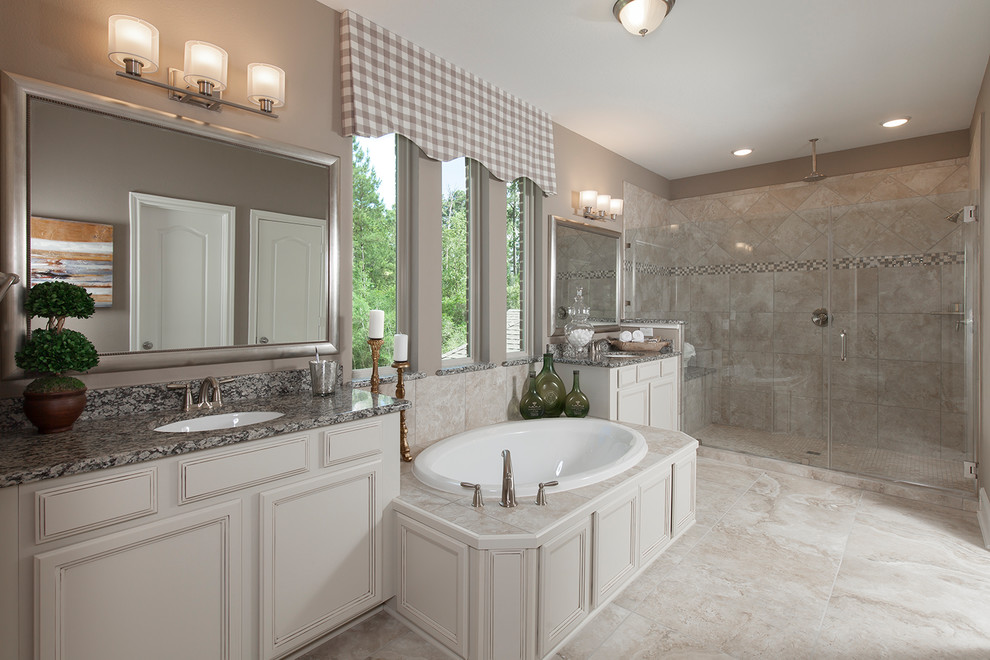 Klassisches Badezimmer mit Schrankfronten mit vertiefter Füllung, weißen Schränken, Einbaubadewanne, Duschnische, beiger Wandfarbe, beigem Boden und Falttür-Duschabtrennung in Houston