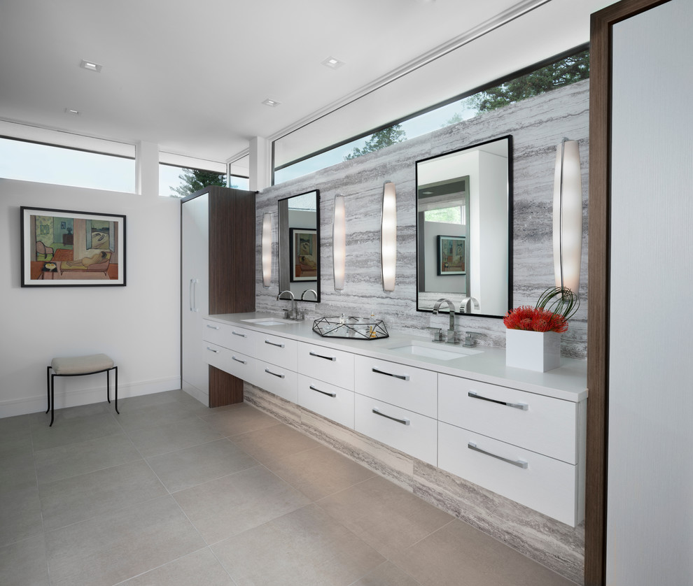 Idée de décoration pour une salle de bain principale design avec un placard à porte plane, des portes de placard blanches, un mur blanc, un lavabo encastré, un plan de toilette blanc et un sol gris.