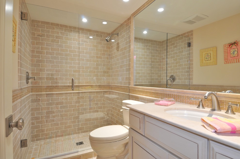 Example of a huge classic master beige tile, brown tile, gray tile, multicolored tile, white tile and ceramic tile travertine floor bathroom design in Tampa with recessed-panel cabinets, distressed cabinets, a one-piece toilet, blue walls and an undermount sink
