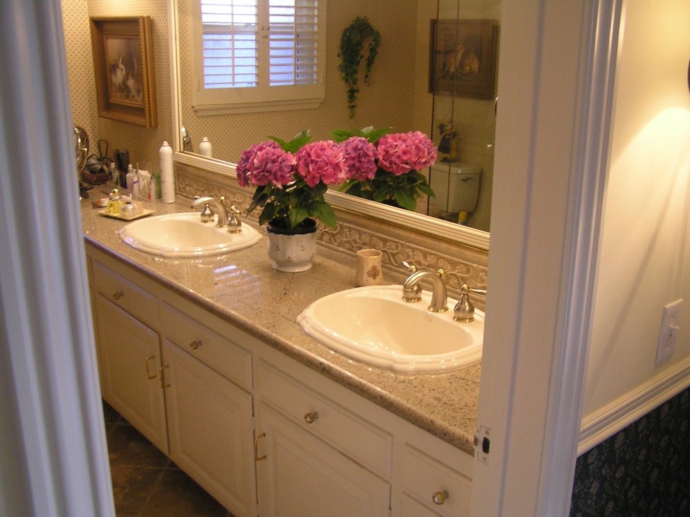 Medium sized contemporary ensuite bathroom in Orange County with a built-in sink, raised-panel cabinets, white cabinets, granite worktops, a corner shower, a two-piece toilet, beige tiles, stone tiles, white walls and travertine flooring.