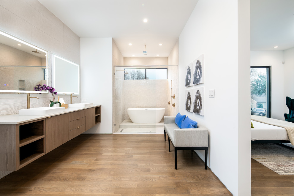 Large trendy master beige tile medium tone wood floor and brown floor bathroom photo in Dallas with flat-panel cabinets, medium tone wood cabinets, white walls, a vessel sink, white countertops, a one-piece toilet, quartz countertops and a hinged shower door