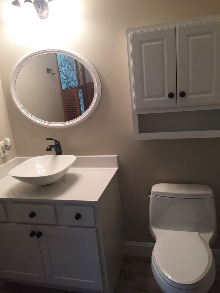Foto de cuarto de baño clásico renovado con lavabo sobreencimera, armarios estilo shaker, puertas de armario blancas, sanitario de dos piezas, paredes blancas, suelo de madera clara y aseo y ducha