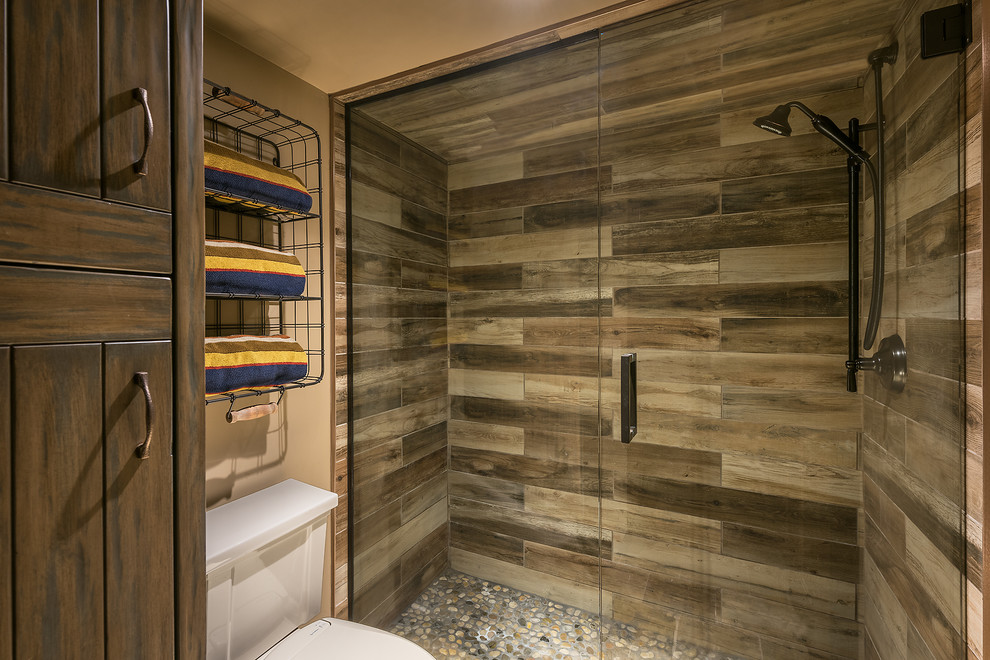 Exemple d'une petite salle de bain principale montagne en bois vieilli avec une douche à l'italienne, WC séparés, des carreaux de porcelaine, un sol en galet, un lavabo encastré, un plan de toilette en granite et une cabine de douche à porte battante.