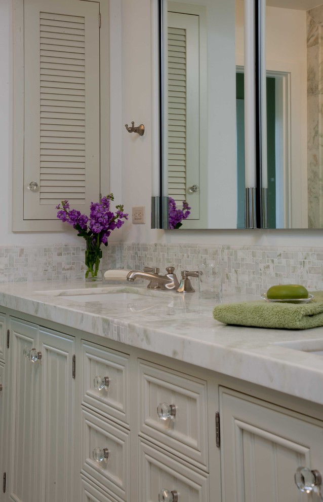 Alcove shower - mid-sized traditional master white tile and mosaic tile mosaic tile floor and white floor alcove shower idea in San Diego with recessed-panel cabinets, white cabinets, white walls, an undermount sink, marble countertops and a hinged shower door