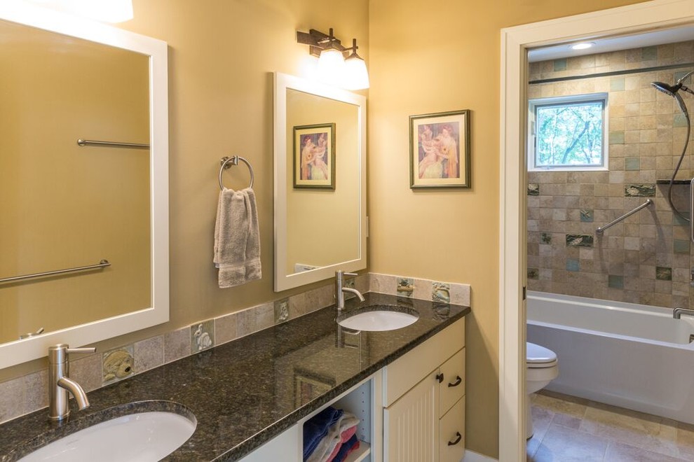 Aménagement d'une salle de bain craftsman avec un plan de toilette en granite.