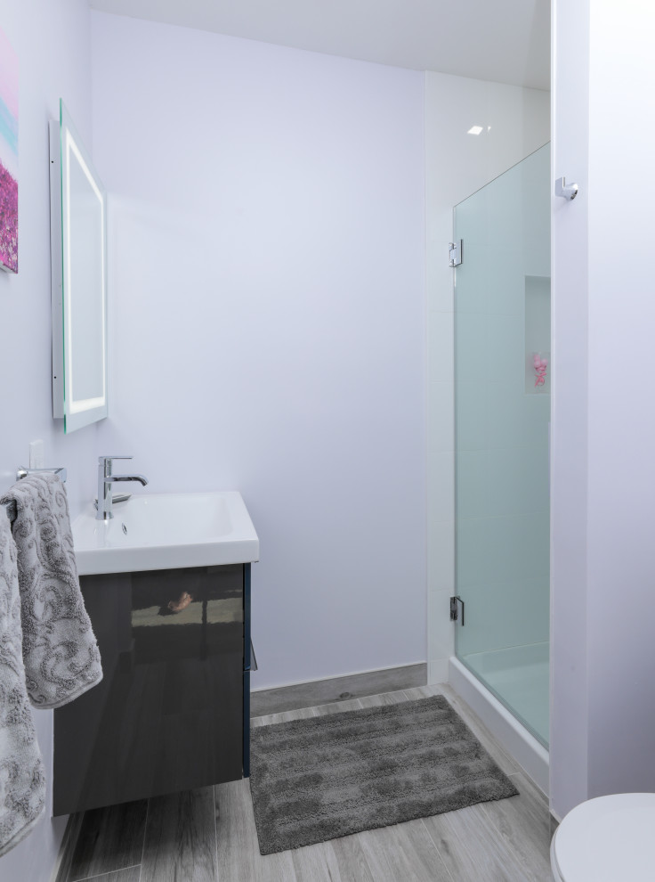Идея дизайна: маленькая главная ванная комната в скандинавском стиле с плоскими фасадами, серыми фасадами, душем в нише, раздельным унитазом, белой плиткой, керамической плиткой, фиолетовыми стенами, полом из керамогранита, раковиной с несколькими смесителями, столешницей из искусственного камня, серым полом, душем с распашными дверями, белой столешницей, нишей, тумбой под одну раковину и подвесной тумбой для на участке и в саду