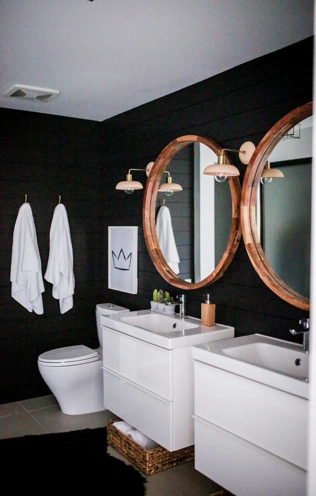 Bild på ett litet funkis en-suite badrum, med släta luckor, vita skåp, en hörndusch, en toalettstol med hel cisternkåpa, svart kakel, svarta väggar, klinkergolv i porslin, ett väggmonterat handfat, bänkskiva i onyx och grått golv