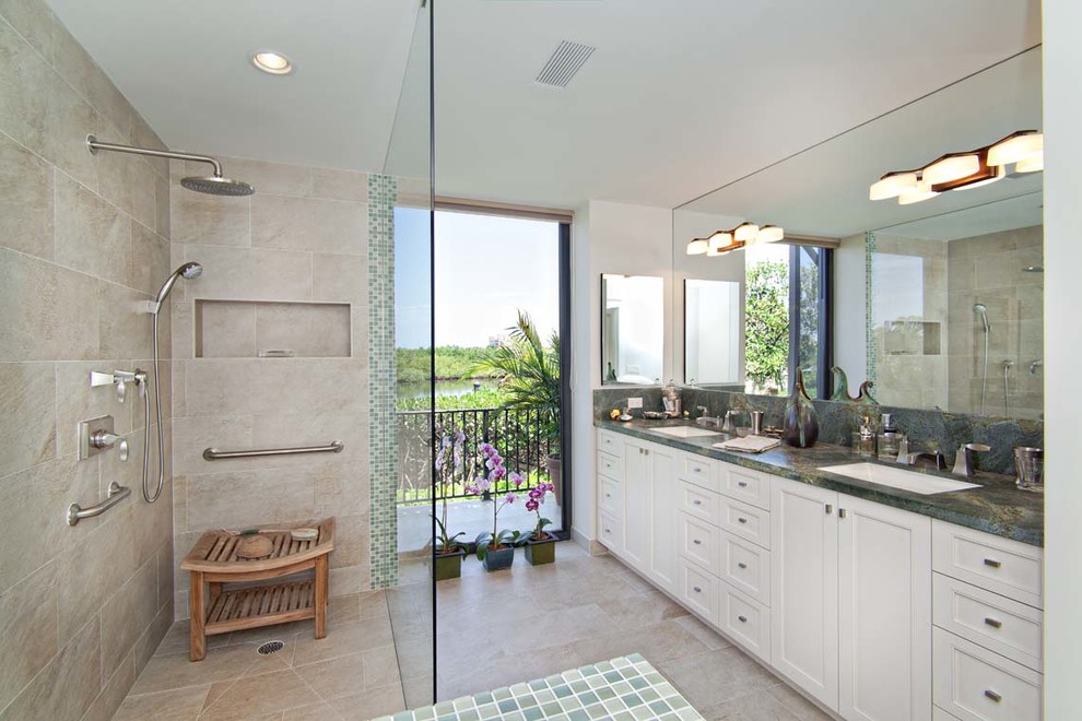 Large classic ensuite bathroom in Miami with recessed-panel cabinets, white cabinets, a walk-in shower, beige tiles, stone tiles, white walls, travertine flooring, a submerged sink, granite worktops and green worktops.