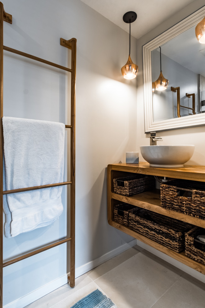 Inspiration för små moderna badrum med dusch, med öppna hyllor, skåp i ljust trä, grå väggar, kalkstensgolv, ett fristående handfat och träbänkskiva