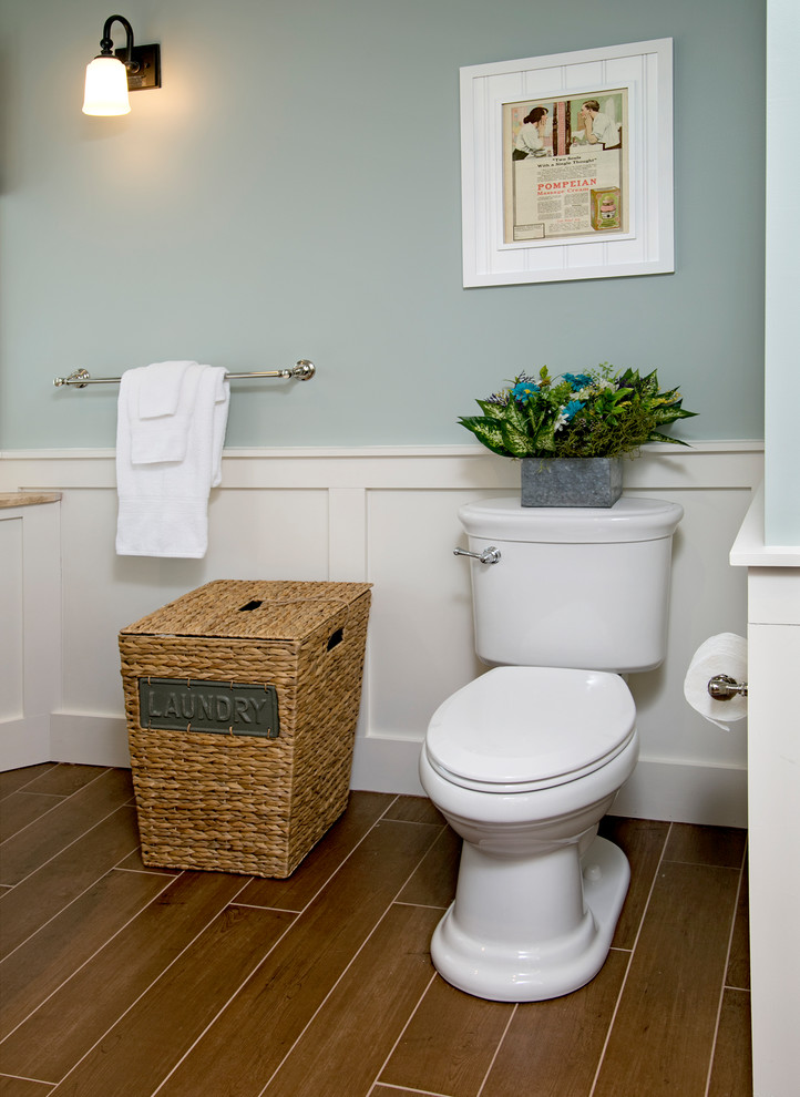 Photo of a large farmhouse ensuite bathroom in Philadelphia with flat-panel cabinets, beige cabinets, a claw-foot bath, a corner shower, a two-piece toilet, beige tiles, porcelain tiles, blue walls, porcelain flooring, a submerged sink, limestone worktops, brown floors and a hinged door.