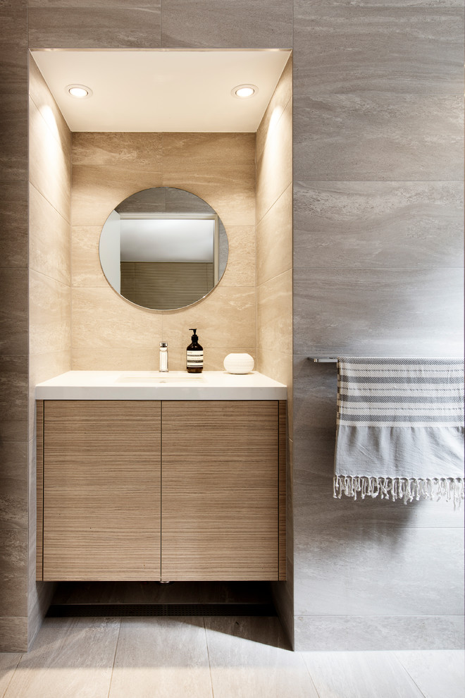 Bild på ett stort funkis vit vitt badrum med dusch, med skåp i ljust trä, grå kakel, porslinskakel, klinkergolv i porslin, ett undermonterad handfat, bänkskiva i kvarts, grått golv och släta luckor